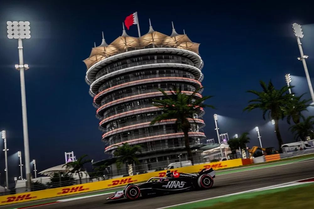 F1 24 kadrovi iz igre - slika Haasovog bolida sa kontrolnim tornjem u pozadini